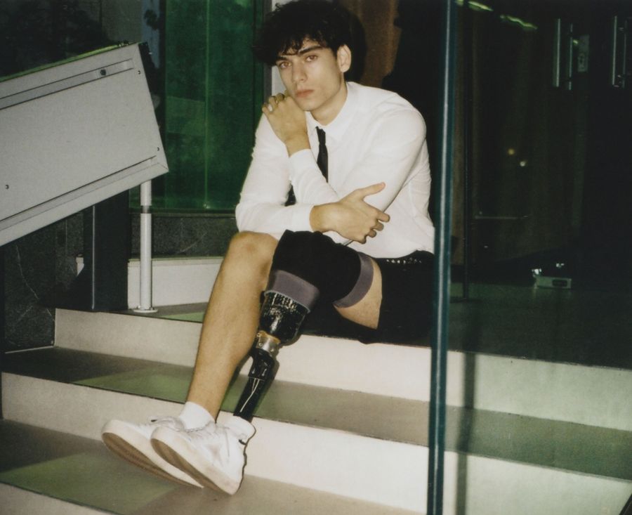 Jan — seated on stairs, white shirt and tie